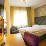 Helles Hotelzimmer mit Doppelbett und Vorhängen